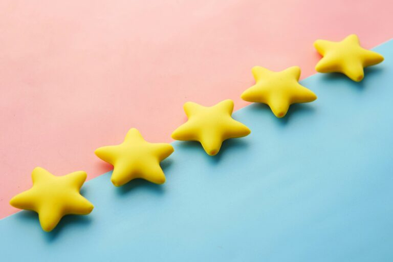 a row of five yellow star-shaped candies or gummies arranged on a light blue background